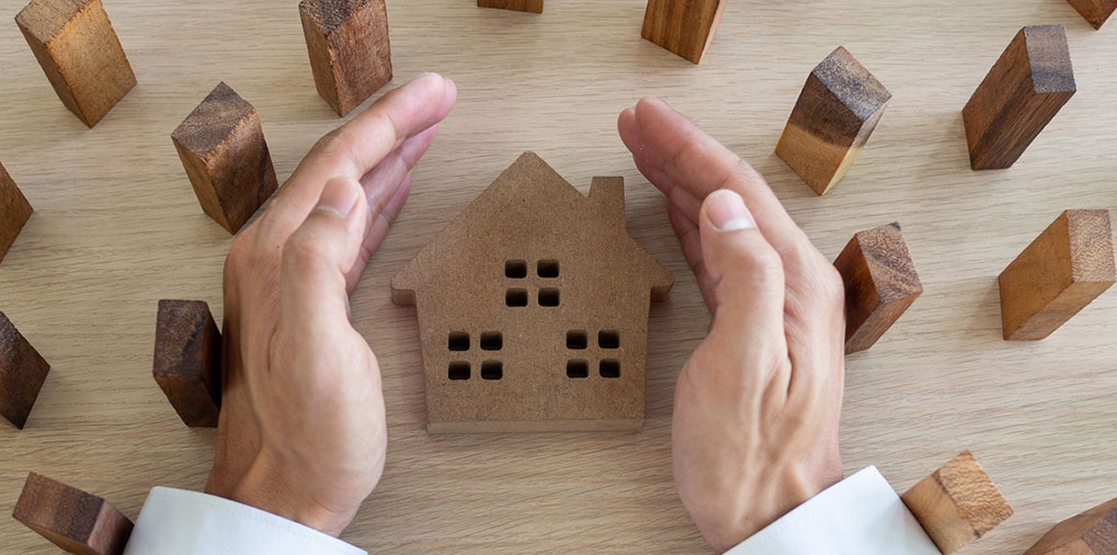 hands protecting a house
